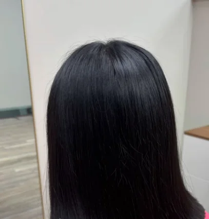 Back view of a sleek, blunt shoulder-length cut on dark hair