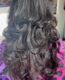 Long dark hair styled in big, voluminous curls