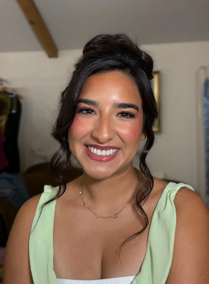 Smiling client in mint green with full glam and an updo