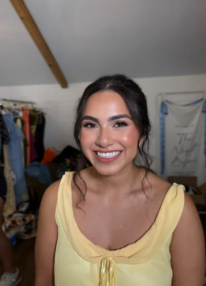 Smiling client in a yellow top with soft bridal-party makeup